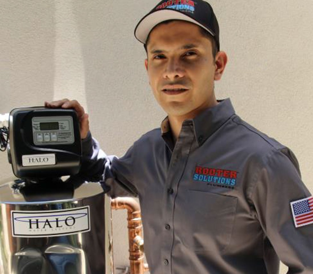 Plumber in uniform installs Halo water system, ensuring top-notch service and quality installation for home plumbing solutions.