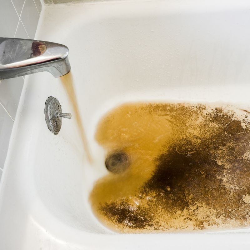 Dirty water filling bathtub, indicating possible plumbing issue or rusty pipes, requiring immediate attention for clean water.