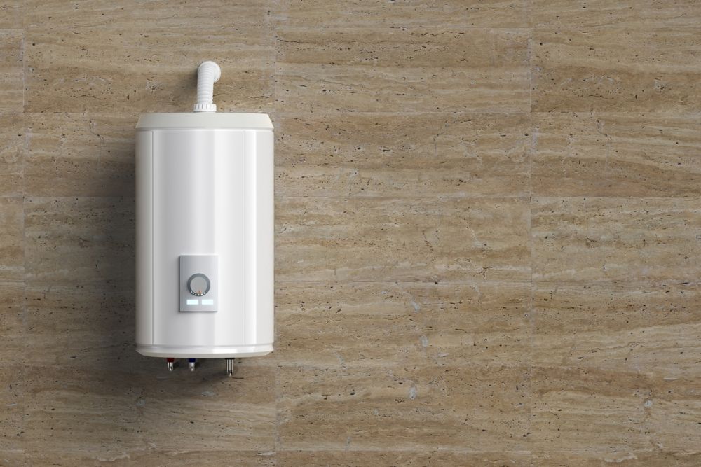 Wall-mounted electric water heater on beige tiled bathroom wall. Energy-efficient home appliance.