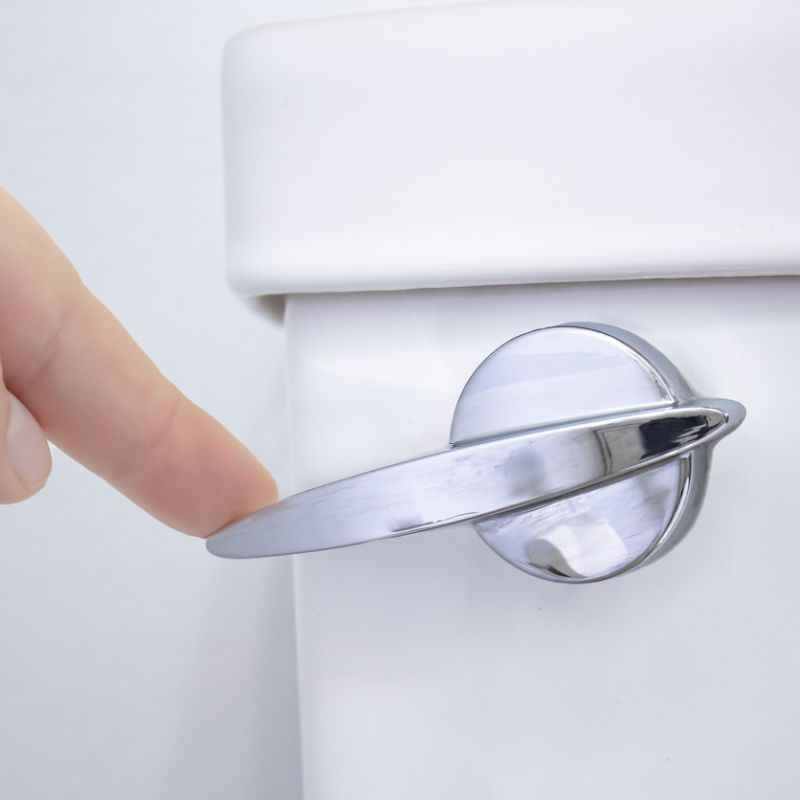 Hand pressing modern toilet flush lever on a white cistern, emphasizing bathroom fixtures and hygiene.