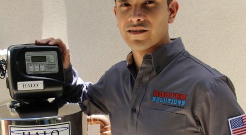 Plumber in uniform installs Halo water system, ensuring top-notch service and quality installation for home plumbing solutions.