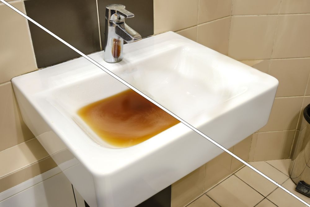 Dirty sink with brown water in a bathroom setting, highlighting plumbing issues and water quality concerns.